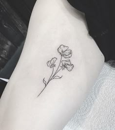 a single flower tattoo on the left thigh