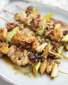 chicken and broccoli skewers with sesame seeds on a white plate, ready to be eaten