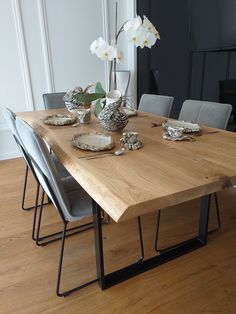 a wooden table with chairs and plates on it