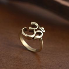 a gold ring with an omen symbol on it sitting on a wooden surface,