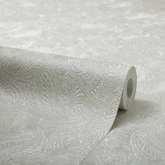 a roll of white wallpaper with an intricate design