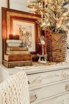 a small christmas tree in a basket on top of a dresser next to some books