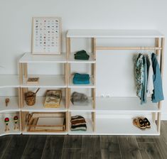 a shelf filled with clothes and shoes next to a wall