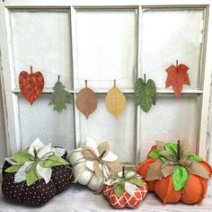 three small pumpkins sitting on top of a window sill