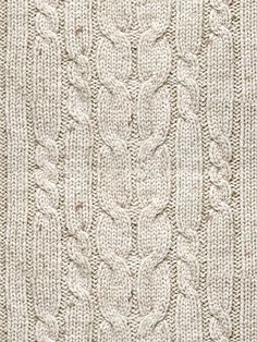 a white knitted blanket with an intricate design on the front and back side,