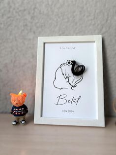 a small figurine is next to a framed photo with the word belif on it