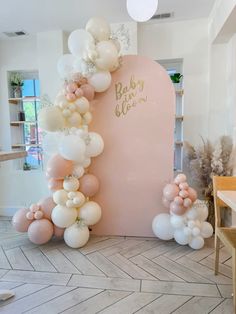 the balloon arch is decorated with white, pink and gold balloons for a baby shower