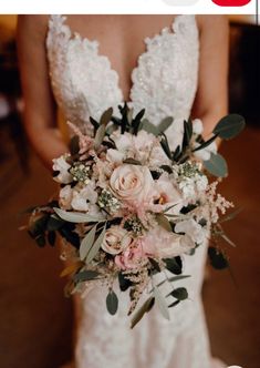 a bridal holding a bouquet of flowers and greenery