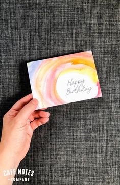 someone holding up a happy birthday card in their hand