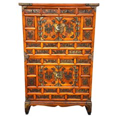 an old wooden dresser with carvings on the front and side panels, all in different colors