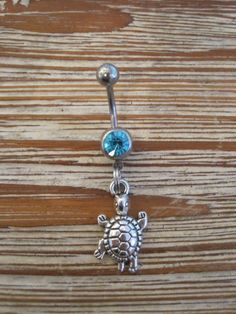 This super cute belly button ring that features a silver turtle charm that hangs from a standard 14 gauge surgical steel barbell with a light blue gem. It measures 3/4 inches long. Thanks for taking a look!   *If you would like this belly button ring in a different color gem or stone, just let me know. I would love to make it for you!* Silver Dangle Belly Rings Nickel Free, Nickel-free Silver Dangle Belly Rings, Silver Hypoallergenic Dangle Belly Rings, Adjustable Nickel-free Sterling Silver Belly Ring, Hypoallergenic Silver Dangle Belly Rings, Silver Surgical Steel Belly Rings As Gift, Adjustable Silver Surgical Steel Belly Rings, Adjustable Nickel-free Stainless Steel Belly Rings, Adjustable Sterling Silver Dangle Belly Rings