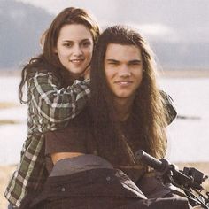 a man and woman sitting on the back of a motorcycle