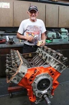 an older man standing next to a large engine