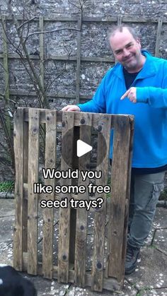 a man standing next to a black dog in front of a wooden crate with the words would you like some tree seed trays?