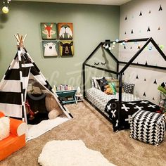 a child's bedroom decorated in black and white with teepee tent bedding