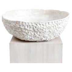 a white bowl sitting on top of a wooden block