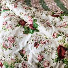 an unmade bed with floral sheets and pillows