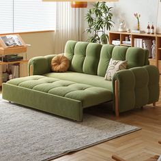 a green couch sitting on top of a wooden floor