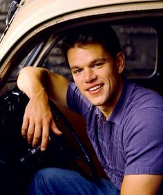 a man sitting in the drivers seat of a car