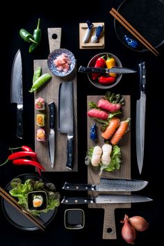 sushi and chopsticks laid out on a cutting board next to various vegetables