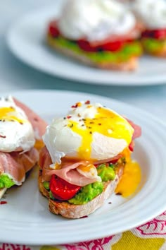 two white plates topped with sandwiches covered in different toppings on top of each other