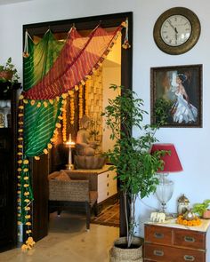 a living room filled with furniture next to a clock on the wall above a doorway