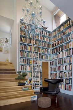 a room filled with lots of books next to a stair case covered in shelves full of books