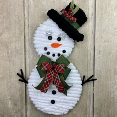 a snowman made out of yarn with a hat and bow