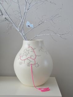 a white vase with some branches in it