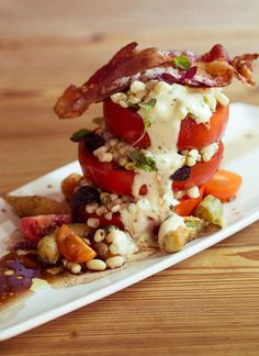 a white plate topped with lots of food on top of a wooden table