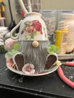 an odd looking tea pot sitting on top of a table next to a pair of scissors