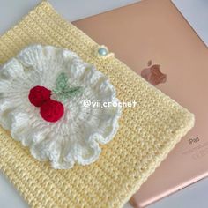 a crocheted apple applique sits on top of an ipad computer case