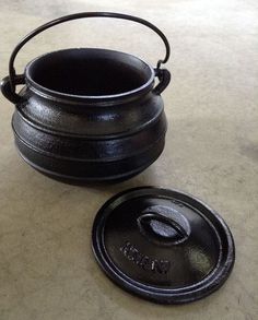 an old black pot with the name annie's collections on it next to a metal lid