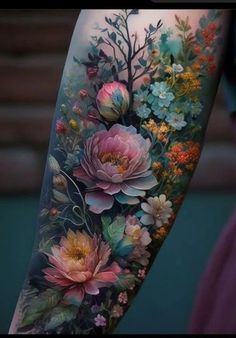 a woman's arm with flowers and leaves painted on the back of her body