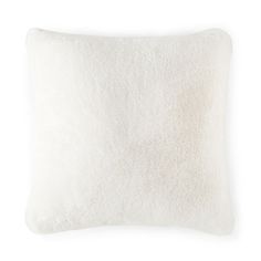 a white pillow with fluffy fur on the front and back side, sitting against a white background