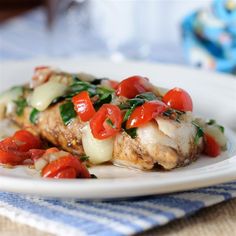 grilled chicken with spinach and tomatoes on a white plate