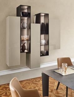 an empty dining room table and chairs in front of a wall mounted cabinet with glass doors