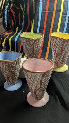 three vases sitting on top of a table next to each other in front of a couch