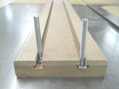 two screws are placed on the side of a piece of plywood plank that is being assembled