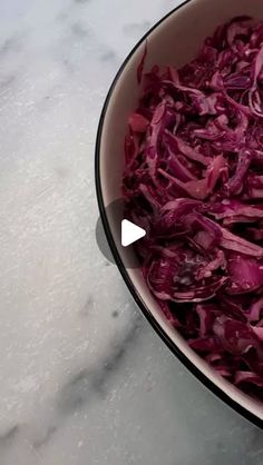 a bowl filled with red cabbage on top of a table