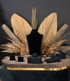 a display with gold feathers and black boxes