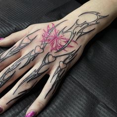 a woman's hand with tattoos on it and pink flowers in the middle of her left hand