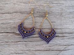 purple beaded earrings with gold accents on wooden background