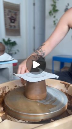 a person is making something out of clay on a potter's wheel with one hand