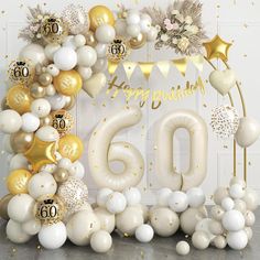 balloons and confetti are arranged in the shape of a 60th birthday arch with gold, white and silver decorations