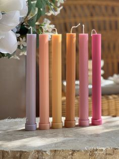 three different colored candles sitting on top of a table