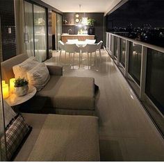 a living room filled with furniture next to a window covered in night time lights and candles