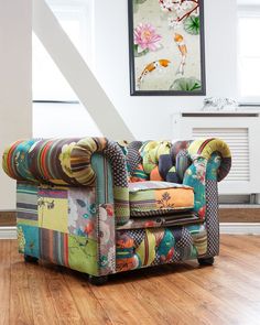 a colorful couch sitting on top of a hard wood floor