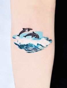 two dolphins jumping out of the water on top of a wave in blue and white ink