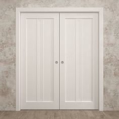 an empty room with two white doors on the wall and wood flooring in front of it